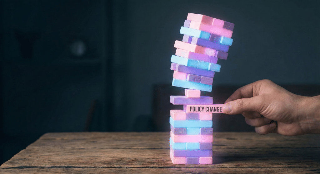 Stack of blocks becoming unstable as one labeled "policy change" is removed, symbolizing how startups built on external platforms can collapse when rules change.
