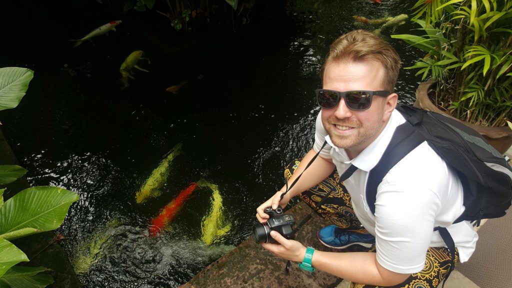 Jacek Francuz photographing koi fish by a pond during private time.